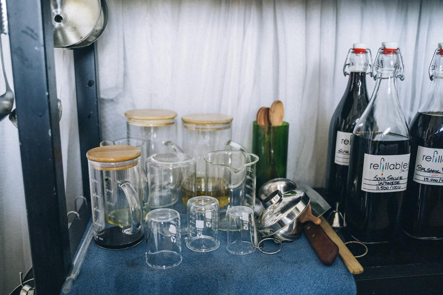 Collection of eco-friendly refillable glass bottles and jars for sustainable shopping. on Earth Wise Budget