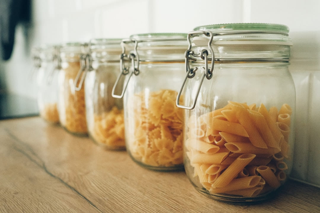 a row of glass jars filled with macaroni and cheese on Earth Wise Budget