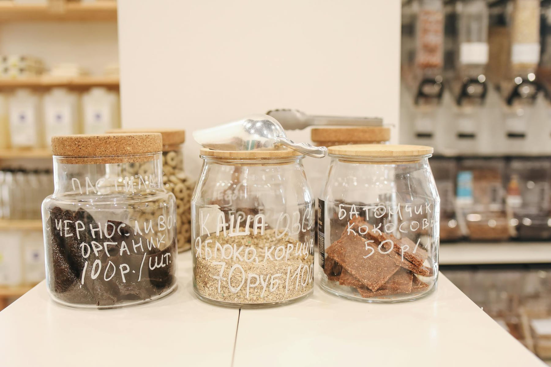 Glass jars with organic snacks on a counter in an eco-friendly zero waste store. on Earth Wise Budget