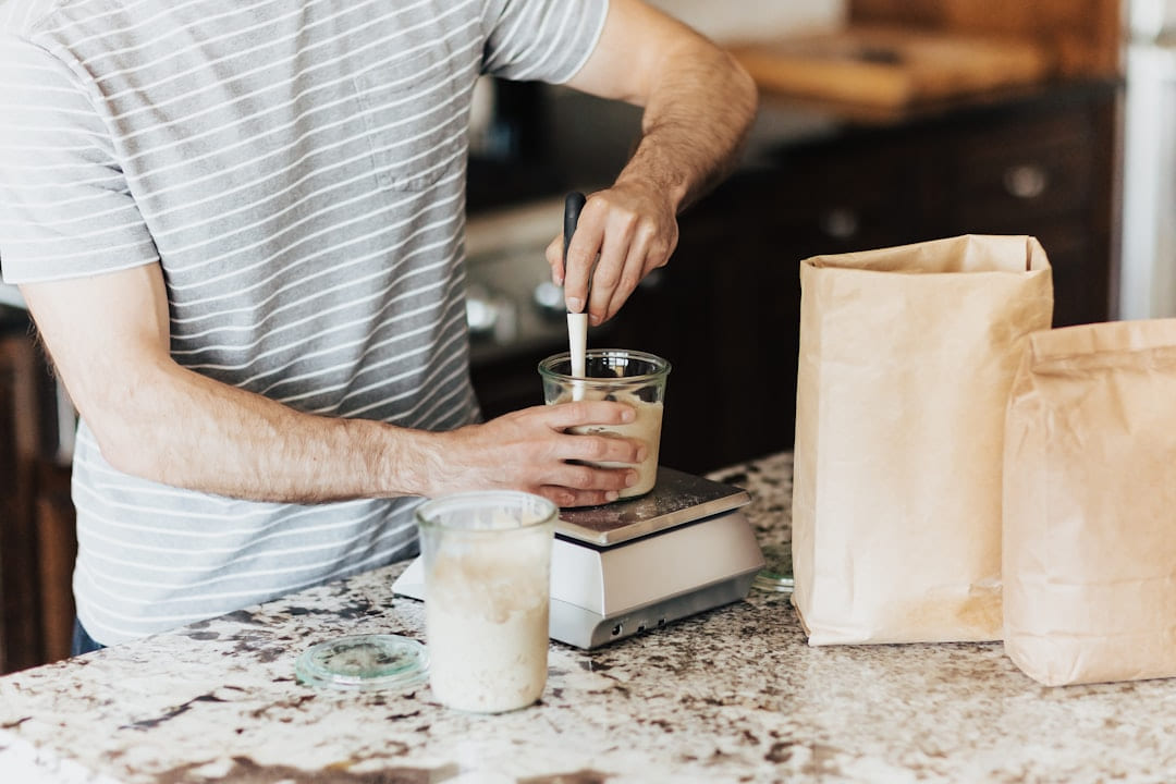 A man is making a smoothie in a kitchen on Earth Wise Budget