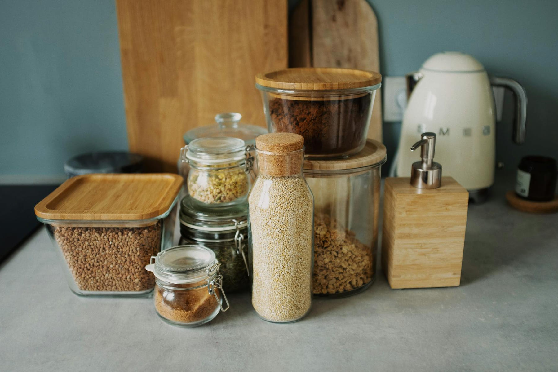 Stylish kitchen setup with glass jars, wooden accents, and a white electric kettle. Ideal for organization. on Earth Wise Budget